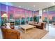 Elegant living room with floor-to-ceiling windows offers panoramic city views and stylish leather furniture at 1335 2Nd St # 402, Sarasota, FL 34236