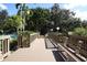 A picturesque wooden bridge leading to a sparkling community pool surrounded by lush landscaping at 1617 Brookhouse Dr # 255, Sarasota, FL 34231