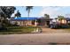 Exterior view of the house with a blue roof tarp and debris scattered around the yard at 1627 Baywinds Ln, Sarasota, FL 34231