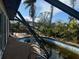 Damaged pool enclosure with view of tropical landscaping and bright blue sky at 1627 Baywinds Ln, Sarasota, FL 34231