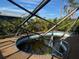 Damaged pool enclosure with view of tropical landscaping and bright blue sky at 1627 Baywinds Ln, Sarasota, FL 34231