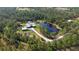 Stunning aerial view of a private estate with a pond surrounded by lush greenery at 19610 66Th E Ave, Bradenton, FL 34211