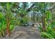 Tranquil backyard setting with lush tropical foliage and bench at 19610 66Th E Ave, Bradenton, FL 34211