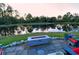 Backyard patio with pond view, featuring a fire pit and comfortable seating; a person kayaking in the lake at 19610 66Th E Ave, Bradenton, FL 34211