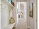 Hallway with seating, coat rack, and artwork offers a welcoming and organized entryway to the home's interior at 19610 66Th E Ave, Bradenton, FL 34211