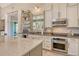 Close-up of a well-appointed kitchen with stainless steel appliances, open shelving, and gray countertops at 19610 66Th E Ave, Bradenton, FL 34211