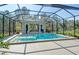 Backyard pool with glass enclosure and view of cabana, surrounded by lush landscaping at 19610 66Th E Ave, Bradenton, FL 34211