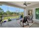 The screened porch features a ceiling fan and a view of the backyard pond at 19610 66Th E Ave, Bradenton, FL 34211