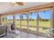 Bright sunroom with expansive windows overlooking a golf course and palm trees at 2080 Padre Island Dr # 211, Punta Gorda, FL 33950