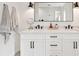 Bright bathroom with dual sink vanity, white cabinets, black hardware, and grey towels at 2202 Waldemere St, Sarasota, FL 34239