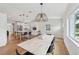 Open-concept dining room with wood floors, a large light fixture, and easy access to the kitchen at 2202 Waldemere St, Sarasota, FL 34239