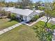 Aerial view of modern home with white exterior, lush landscaping, and driveway at 2202 Waldemere St, Sarasota, FL 34239