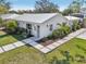 Charming single-story home featuring modern white siding, metal roof, and beautifully landscaped front yard at 2202 Waldemere St, Sarasota, FL 34239