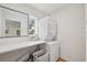 Bright laundry room with stacked washer and dryer, quartz countertop, and a built-in mirror at 2202 Waldemere St, Sarasota, FL 34239