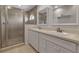 Bright bathroom features dual sinks with white cabinets and a glass enclosed shower at 27 Inlets Blvd # 27, Nokomis, FL 34275