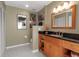 Well-lit bathroom features a wood vanity with a black countertop, a tiled floor, and neutral paint at 27 Inlets Blvd # 27, Nokomis, FL 34275