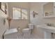 Cozy half bathroom featuring a stylish pedestal sink, ceramic tile flooring, and natural light at 27 Inlets Blvd # 27, Nokomis, FL 34275