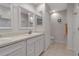 Bright bathroom featuring dual sinks with white cabinets and a separate toilet room for privacy at 27 Inlets Blvd # 27, Nokomis, FL 34275