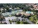 Aerial view of a community clubhouse, pool, and tennis courts surrounded by lush landscaping and palm trees at 27 Inlets Blvd # 27, Nokomis, FL 34275