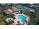 Overhead view of a community pool, jacuzzi, and tennis courts, highlighting the recreational options for residents at 27 Inlets Blvd # 27, Nokomis, FL 34275