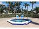 Community hot tub bordered in blue tile sitting on brick with two chairs nearby at 27 Inlets Blvd # 27, Nokomis, FL 34275