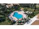 Aerial view of a community pool featuring blue water, surrounding chairs, palm trees, and building at 27 Inlets Blvd # 27, Nokomis, FL 34275