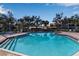 Outdoor pool featuring clear blue water, lounge chairs, and an in-ground spa surrounded by trees at 27 Inlets Blvd # 27, Nokomis, FL 34275