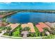 An aerial view reveals a lakefront community with tile roofs, backyard pools, and lush landscaping at 272 Maraviya Blvd, Nokomis, FL 34275