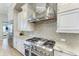 This kitchen showcases stainless steel appliances, a stylish range hood, and light grey backsplash tiles at 272 Maraviya Blvd, Nokomis, FL 34275