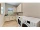 Laundry room featuring granite countertops, white cabinets, and a front-load washer and dryer at 272 Maraviya Blvd, Nokomis, FL 34275