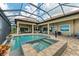 The screened-in outdoor pool and spa area features brick pavers at 272 Maraviya Blvd, Nokomis, FL 34275