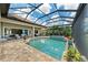 The screened-in outdoor pool and spa area features brick pavers and tropical landscaping at 272 Maraviya Blvd, Nokomis, FL 34275