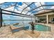 Enclosed pool area with a hot tub overlooking a serene lake at 272 Maraviya Blvd, Nokomis, FL 34275