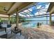 Outdoor living space with a screened pool, spa and seating area overlooking the lake at 272 Maraviya Blvd, Nokomis, FL 34275