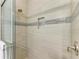 Detailed view of the shower featuring modern tile, a built-in niche, and a glass door at 272 Maraviya Blvd, Nokomis, FL 34275