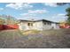 View of the backyard that features a red wooden fence and patio with lounge chairs at 2746 Tangelo Dr, Sarasota, FL 34239