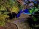 Outdoor patio with dining table and chairs surrounded by lush tropical landscaping and low-lighting at 2785 Sydelle St, Sarasota, FL 34237