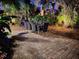 Evening view of the backyard dining area with brick pavers surrounded by lush landscaping at 2785 Sydelle St, Sarasota, FL 34237