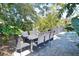 Backyard view of the outdoor dining area with brick pavers surrounded by lush landscaping at 2785 Sydelle St, Sarasota, FL 34237