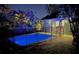 Backyard in the evening showcases the shimmering pool surrounded by brick pavers and tropical foliage at 2785 Sydelle St, Sarasota, FL 34237