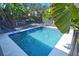 A refreshing in-ground pool is surrounded by lush tropical landscaping and secured with a safety fence at 2785 Sydelle St, Sarasota, FL 34237