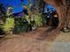 Evening view of the brick paver patio surrounded by a large tree and lush tropical foliage at 2785 Sydelle St, Sarasota, FL 34237