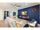 Modern living room featuring a vibrant blue accent wall, wood floors, and natural light at 2823 Marshall Dr, Sarasota, FL 34239