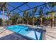 Screened-in pool with a tiled spa and tropical landscaping at 2823 Marshall Dr, Sarasota, FL 34239