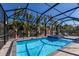 Screened-in pool with spa, lounge chairs, and tropical plants at 2823 Marshall Dr, Sarasota, FL 34239