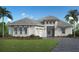 Elegant single-story home boasting a paver driveway, lush landscaping, and a three-car garage at 300 Blue Pearl Ct, Sarasota, FL 34240