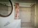 Elegant bathroom featuring a tiled shower with glass doors and a decorative oval mirror at 3060 Arrowhead Rd, Venice, FL 34293