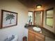 Charming bathroom featuring granite countertops, a decorative mirror, and a palm tree art piece at 3060 Arrowhead Rd, Venice, FL 34293