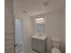 Well-lit bathroom with a gray vanity, undermount sink, and matching tile floors and shower at 3325 Woodmont Dr, Sarasota, FL 34232