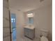 Bathroom featuring grey vanity with solid surface countertop at 3325 Woodmont Dr, Sarasota, FL 34232